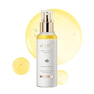 d’alba White Truffle First Spray Serum in einer Flasche mit goldenem Sprühkopf vor gelben Serumtropfen
