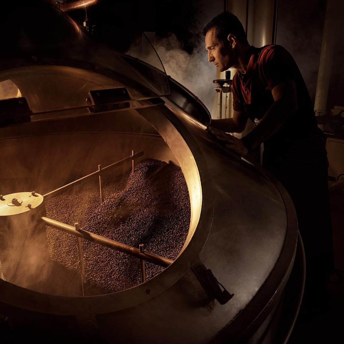 Röstmeister von Caffè Mauro prüft Kaffeebohnen in der Rösttrommel